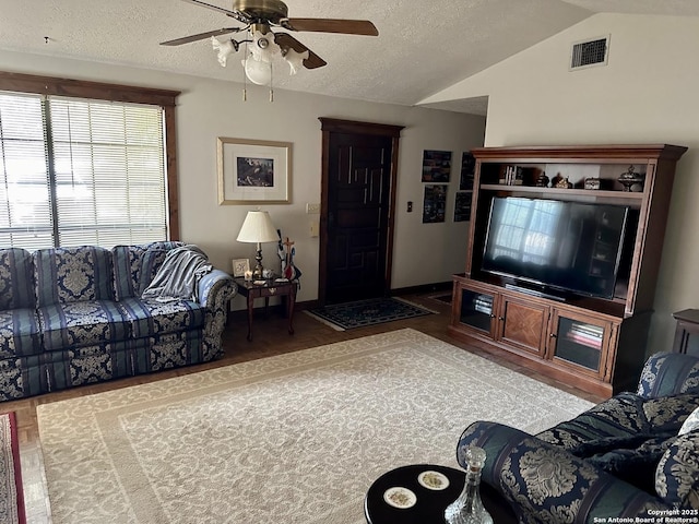 living area with vaulted ceiling, a textured ceiling, ceiling fan, and visible vents