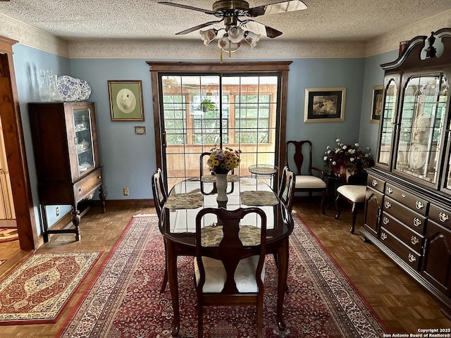 dining space featuring baseboards, ceiling fan, and a textured ceiling