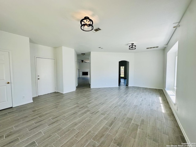 1064 Maltese Ln, San Antonio, TX 78260 - unfurnished living room with arched walkways, light wood-style flooring, visible vents, and a ceiling fan