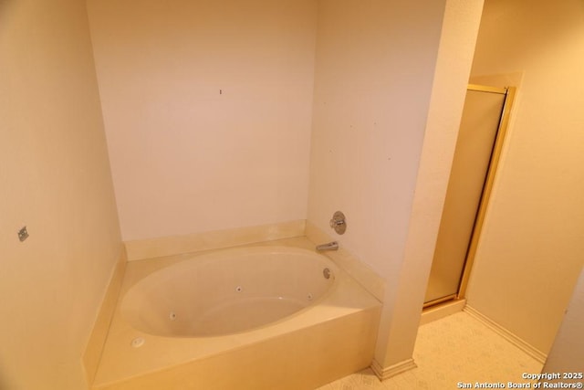bathroom featuring a tub with jets and a stall shower