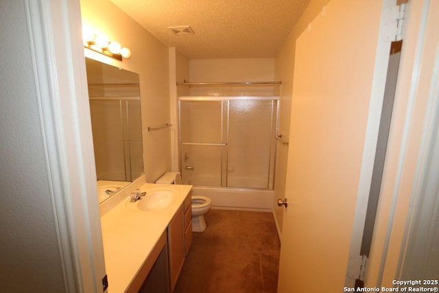 full bath with vanity, toilet, a textured ceiling, visible vents, and combined bath / shower with glass door