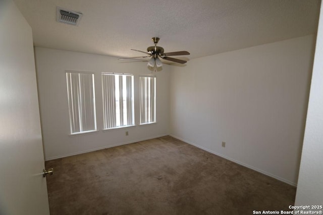 unfurnished room featuring a textured ceiling, visible vents, carpet, baseboards, and ceiling fan