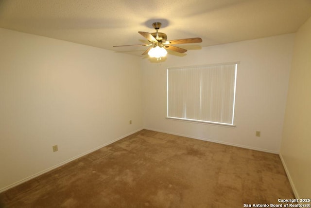 carpeted empty room with baseboards and ceiling fan