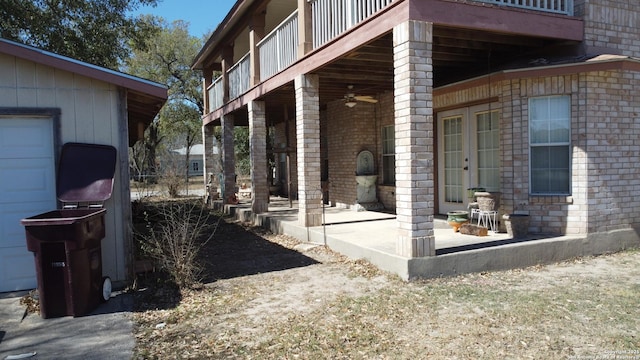 view of home's exterior with a balcony, a patio, and brick siding