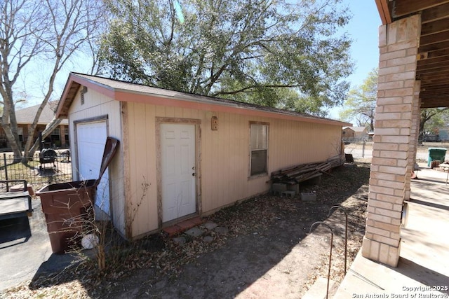 view of outbuilding with an outdoor structure, a garage, and fence