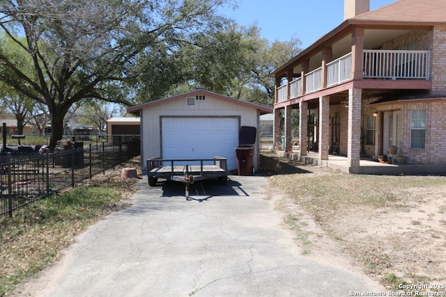 detached garage featuring fence and aphalt driveway