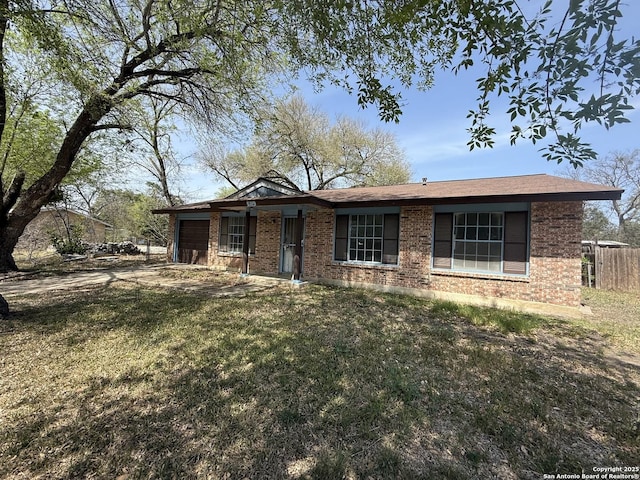 5119 Village Ct, San Antonio, TX 78218 - ranch-style house featuring brick siding, a front lawn, fence, and an attached garage