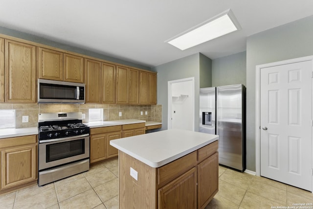 kitchen with backsplash, light countertops, light tile patterned floors, and stainless steel appliances