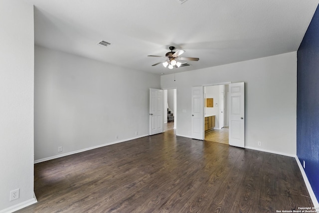 unfurnished bedroom featuring visible vents, baseboards, a ceiling fan, and wood finished floors