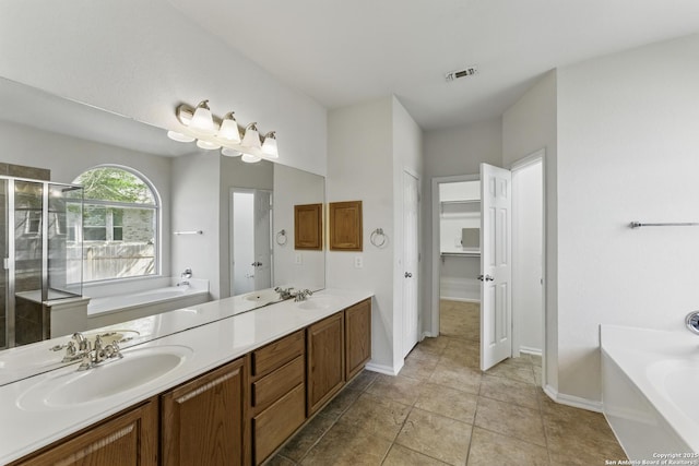 full bath featuring a garden tub, a sink, a stall shower, double vanity, and baseboards