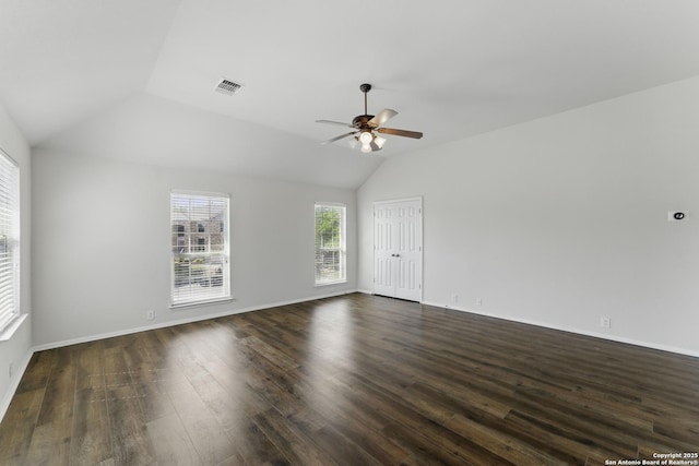 interior space featuring lofted ceiling, baseboards, dark wood-style floors, visible vents, and ceiling fan