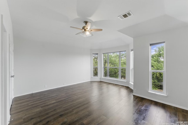 unfurnished room featuring visible vents, baseboards, a ceiling fan, and dark wood-style floors