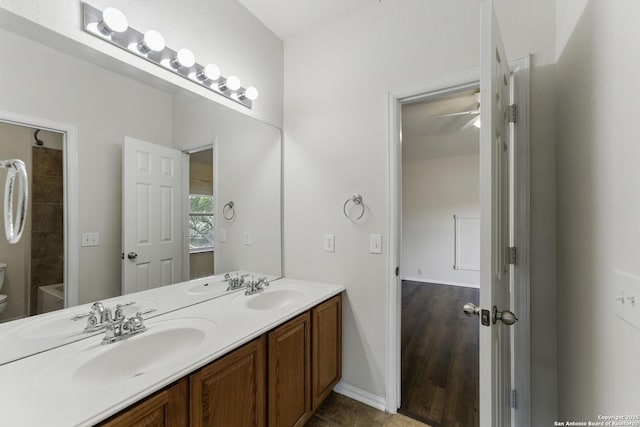full bath featuring double vanity, a sink, and toilet