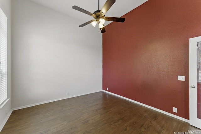 unfurnished room with ceiling fan, vaulted ceiling, baseboards, and dark wood-style floors
