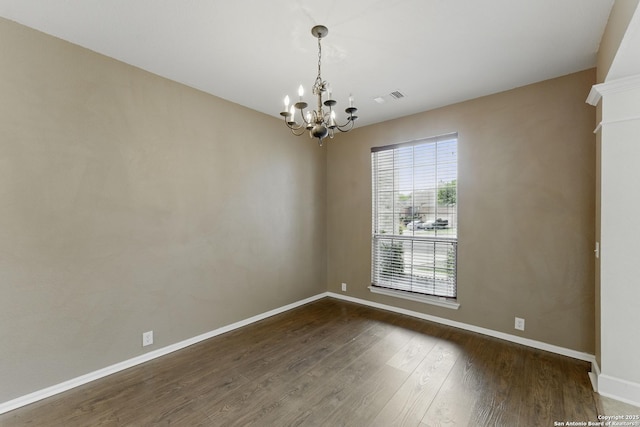 unfurnished room featuring a chandelier, dark wood-style flooring, baseboards, and visible vents