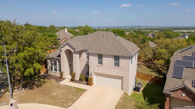 view of front facade featuring a garage, fence, brick siding, a shingled roof, and concrete driveway