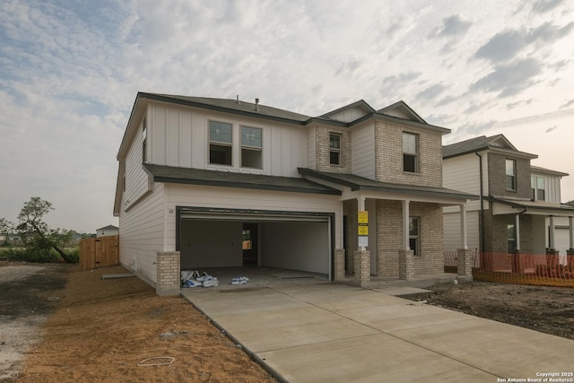 6003 Cienna Cv, San Antonio, TX 78222 - view of front of home with a garage, brick siding, board and batten siding, concrete driveway, and covered porch