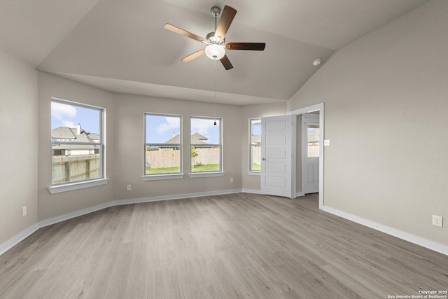 unfurnished room with light wood-style flooring, a healthy amount of sunlight, lofted ceiling, and a ceiling fan