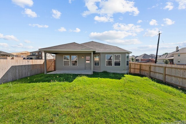 back of property with a fenced backyard, a shingled roof, a residential view, a patio area, and a lawn