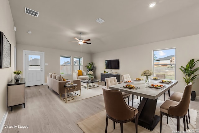 dining space featuring ceiling fan, lofted ceiling, light wood finished floors, and visible vents