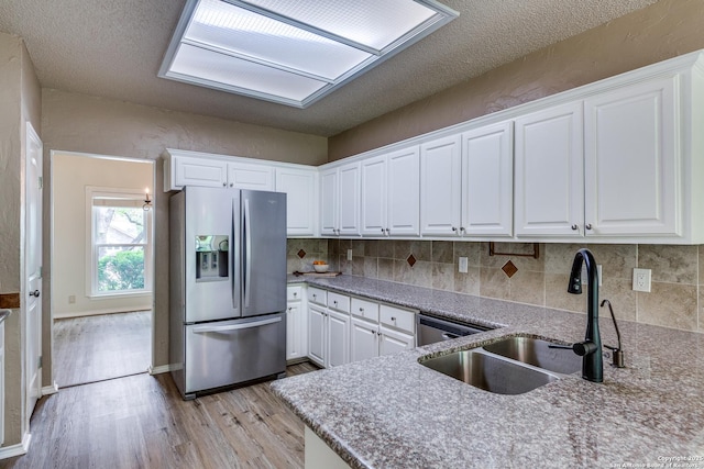 2312 Encino Xing, San Antonio, TX 78259 - kitchen featuring white cabinetry, stainless steel fridge with ice dispenser, backsplash, a sink, and light wood finished floors
