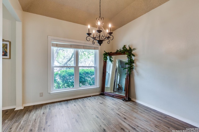 2312 Encino Xing, San Antonio, TX 78259 - unfurnished room featuring baseboards, a notable chandelier, and wood finished floors
