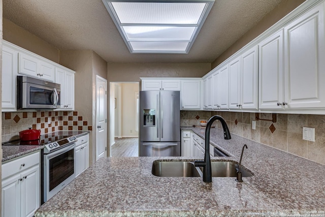 2312 Encino Xing, San Antonio, TX 78259 - kitchen featuring white cabinetry, a sink, stainless steel appliances, and backsplash
