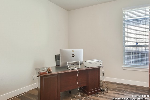 office area with baseboards and wood finished floors