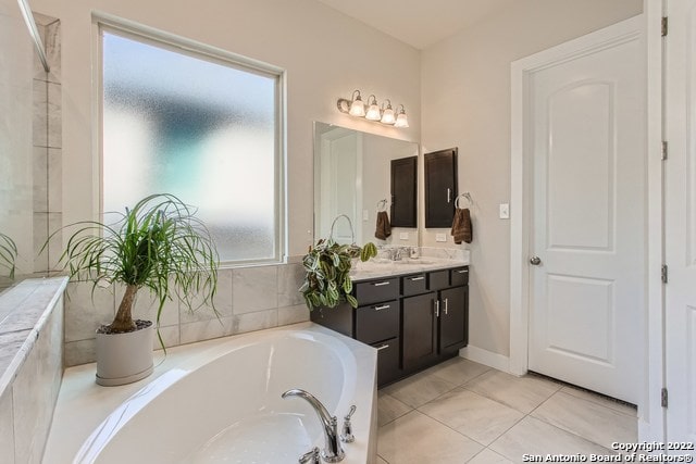 full bathroom with tile patterned floors, vanity, and a garden tub