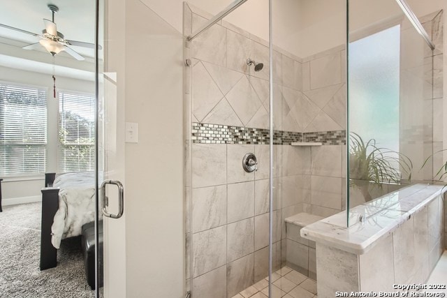 bathroom featuring ceiling fan and a shower stall