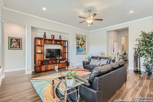 living room featuring a ceiling fan, wood finished floors, baseboards, ornamental molding, and recessed lighting