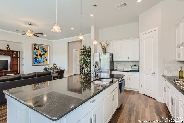 kitchen with a sink, appliances with stainless steel finishes, dark wood-style floors, open floor plan, and visible vents