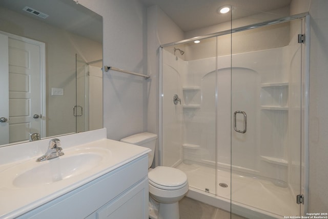 bathroom with vanity, toilet, visible vents, and a stall shower