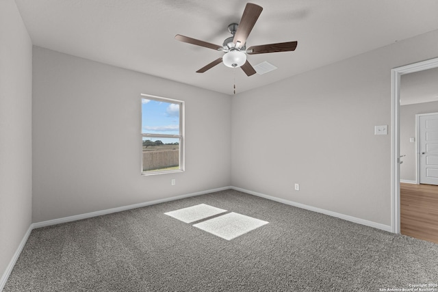 spare room featuring carpet floors, a ceiling fan, and baseboards