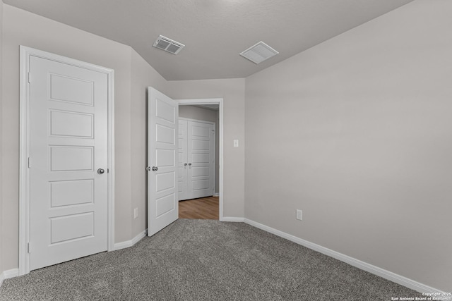 unfurnished bedroom featuring carpet flooring, baseboards, and visible vents