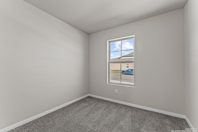 unfurnished room featuring carpet floors and baseboards