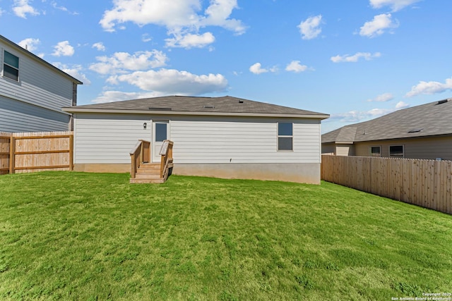 back of house featuring a fenced backyard and a yard