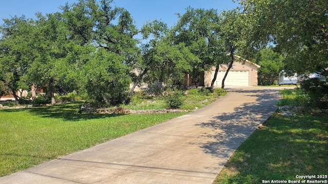 260 Campbell, Canyon Lake, TX 78133 - view of front of house with stucco siding, driveway, a garage, and a front lawn