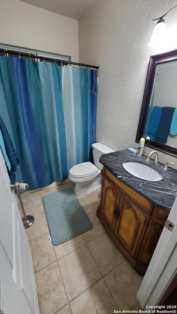 260 Campbell, Canyon Lake, TX 78133 - full bath featuring toilet, a textured wall, vanity, and tile patterned floors