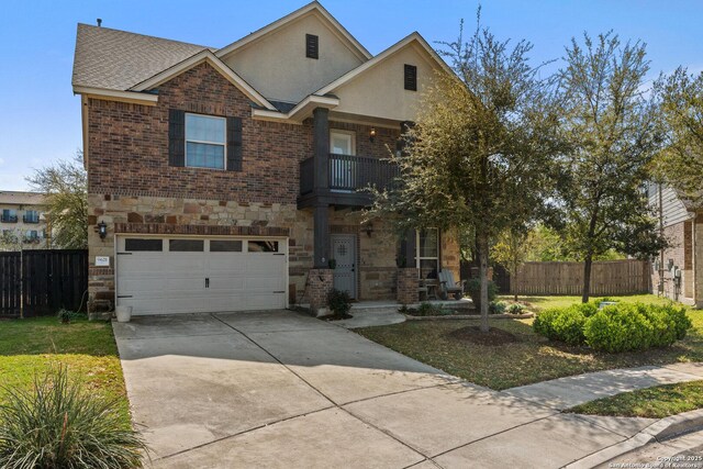view of front facade with a balcony, an attached garage, fence, and stone siding