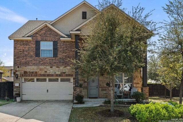 traditional home featuring fence, stone siding, driveway, brick siding, and a garage