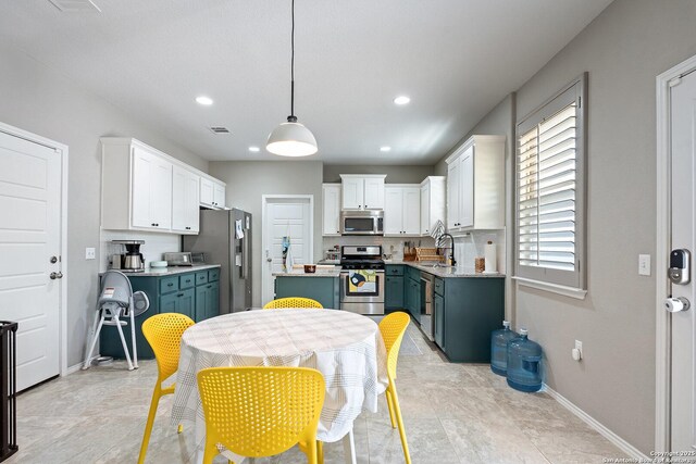 kitchen with white cabinetry, a sink, light countertops, and appliances with stainless steel finishes