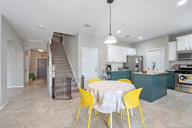 dining space featuring arched walkways, baseboards, visible vents, and stairway