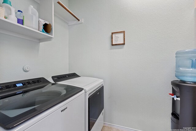 laundry area featuring independent washer and dryer, a textured wall, and laundry area