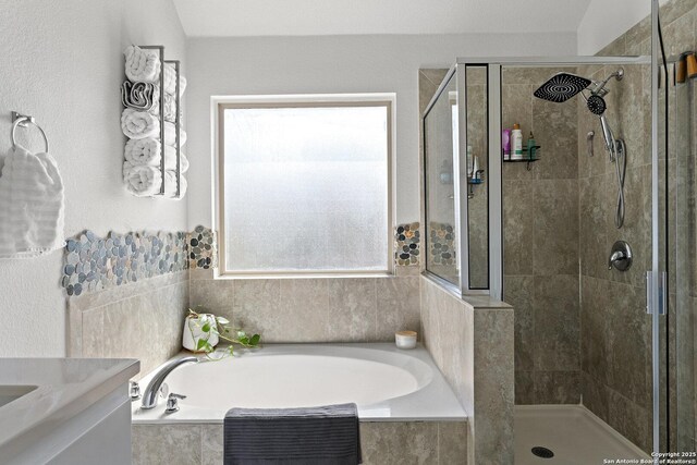 full bathroom featuring a bath, vanity, and a shower stall