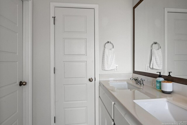 full bathroom with double vanity and a sink