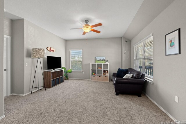 living area with baseboards, carpet floors, and a ceiling fan