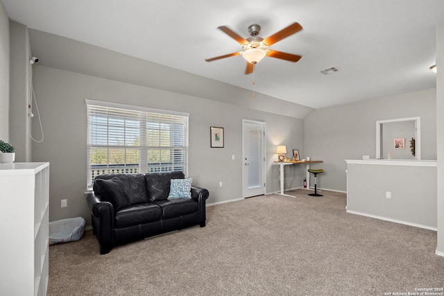 carpeted living area featuring baseboards, lofted ceiling, visible vents, and a ceiling fan