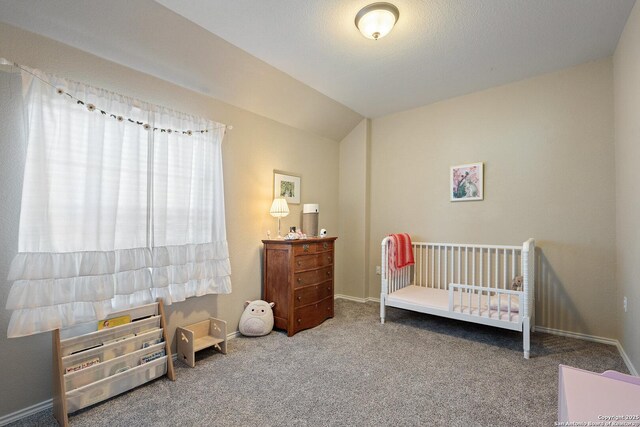 carpeted bedroom featuring baseboards, lofted ceiling, and a nursery area