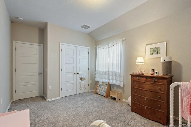 carpeted bedroom with baseboards, vaulted ceiling, and a closet